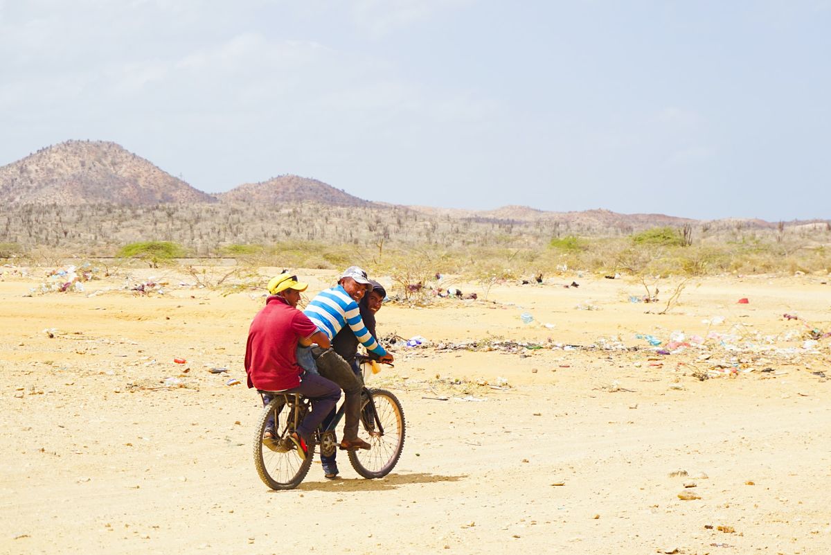 3 men on bike desert colombia