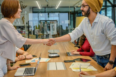 man-woman-shaking-hands-at-sales-meeting