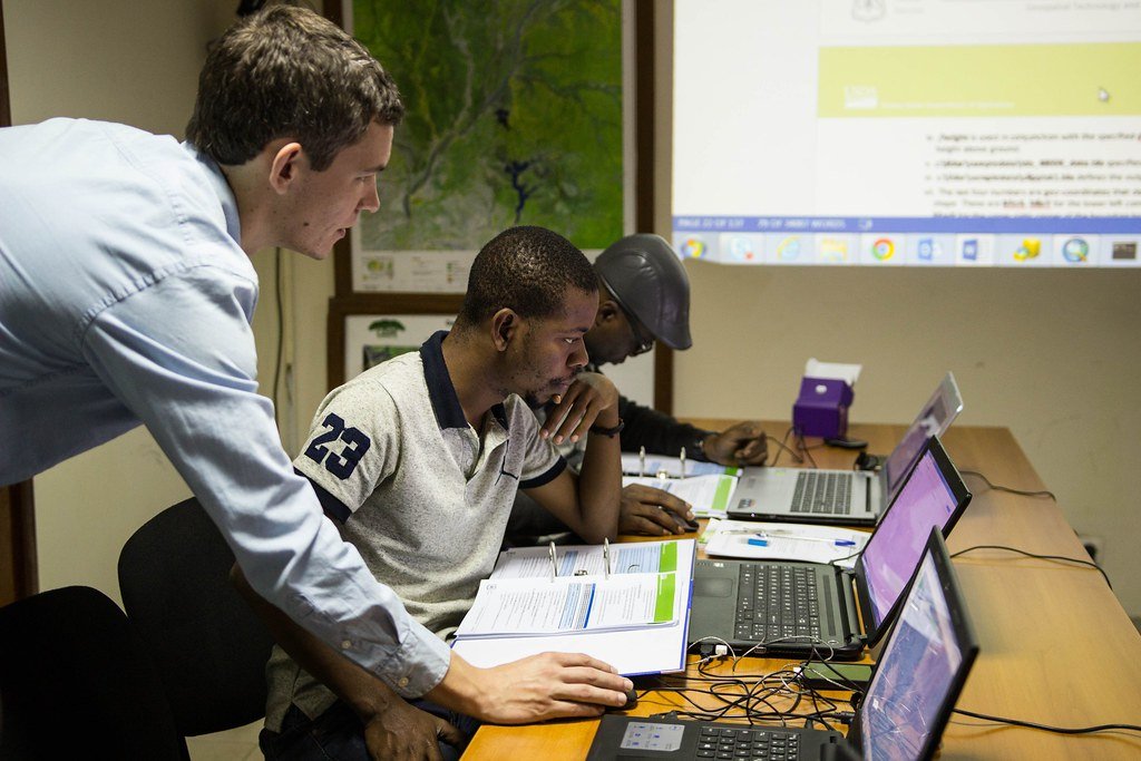 A manager with his team looking at laptops